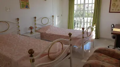 a bedroom with two beds and a couch and a window at Algarve Paraíso Casa Lagos e Relvas in Estói
