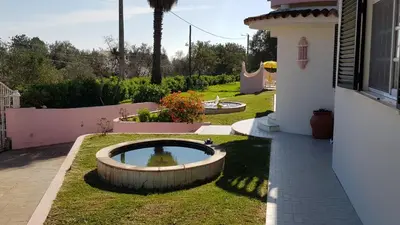 a garden with a pond in the middle of a yard at Algarve Paraíso Casa Lagos e Relvas in Estói