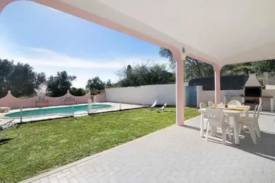 a patio with a table and chairs and a pool at Algarve Paraíso Casa Lagos e Relvas in Estói