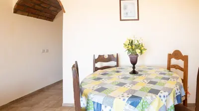 a dining room table with a vase of flowers on it at Apartamento Tio Pedro - by bedzy in Albufeira
