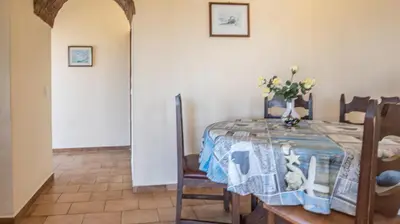 a dining room with a table with a vase on it at Apartamento Tio Pedro - by bedzy in Albufeira