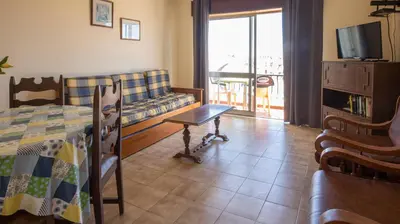 a living room with a bed and a couch and a television at Apartamento Tio Pedro - by bedzy in Albufeira