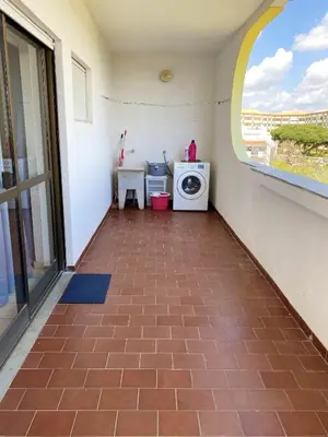 a couch sitting in a room with two tables at Charming Vilamoura Apartment with Shared Pool in Vilamoura