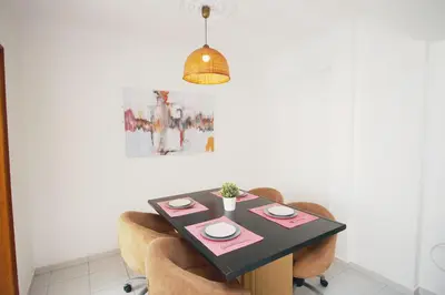 a living room with a black table and chairs at A Santo, Quarteira - By Urbinvest Algarve in Quarteira