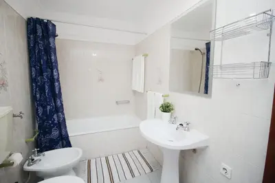a white bathroom with a sink and a toilet at A Santo, Quarteira - By Urbinvest Algarve in Quarteira