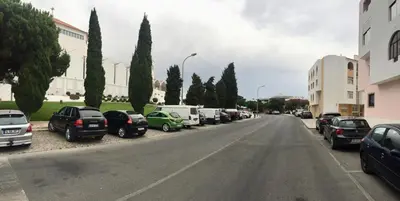 a street with cars parked on the side of a road at A Santo, Quarteira - By Urbinvest Algarve in Quarteira