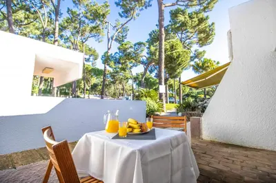 a table with a plate of fruit on it on a patio at Vilamoura Golf Studio With Pool by Homing in Vilamoura