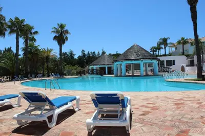 a swimming pool with two lounge chairs and a gazebo at Tulio 2 Bedroom Luxury Apartment located in Encosta Do Lago in Quinta do Lago