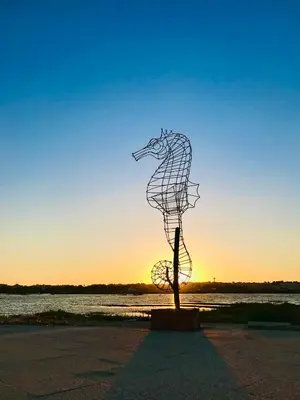 a statue of a seahorse on the beach at sunset at Fisherman´s Cave in Faro