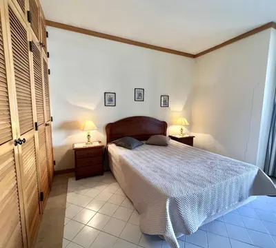 a bedroom with a bed and two lamps on tables at Talia XII - Near the beach by HD PROPERTIES in Vilamoura