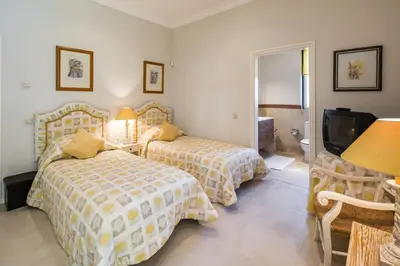 a hotel room with two beds and a television at Sera - Luxury 3 bedroom apartment with pool, golf,beach in Ludo