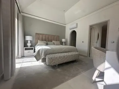 a bedroom with a large bed and a chair at Sunshine - PINHEIROS ALTOS in Quinta do Lago