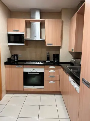 a kitchen with wooden cabinets and a stove top oven at Barracuda ByTheSea in Albufeira