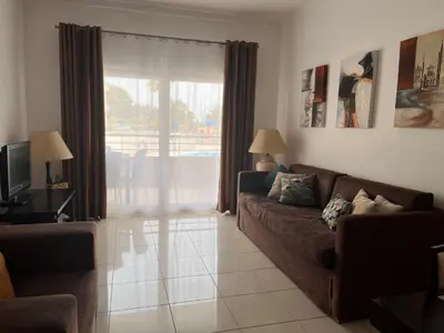 a living room with a couch and a large window at Barracuda ByTheSea in Albufeira