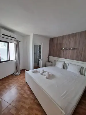 a bedroom with a large white bed with towels on it at AAA T2 Awesome Albufeira Apartments Piscina Marina in Albufeira
