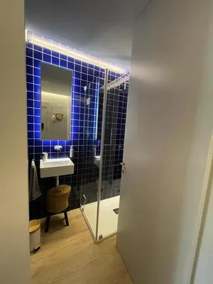 a blue tiled bathroom with a sink and a mirror at Victory Village 10C in Quinta do Lago