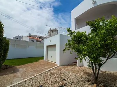 a white house with a small tree in front of it at Villa Double Joy by Stay ici Algarve Holiday Rental in Albufeira