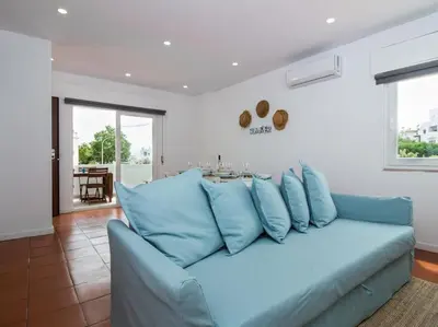 a blue couch in a living room with a table at Villa Double Joy by Stay ici Algarve Holiday Rental in Albufeira