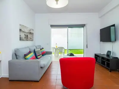 a living room with a couch and a red chair at Villa Double Joy by Stay ici Algarve Holiday Rental in Albufeira