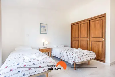 a bedroom with two beds and a wooden cabinet at #088 T2 São Rafael 64B by Home Holidays in Albufeira