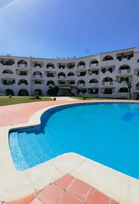 an empty swimming pool in front of a building at 211 Apartamento moderno com vista para a piscina no centro da cidade in Albufeira