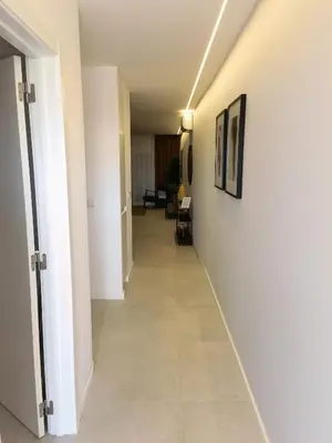 a hallway with white walls and tile floors at 211 Apartamento moderno com vista para a piscina no centro da cidade in Albufeira