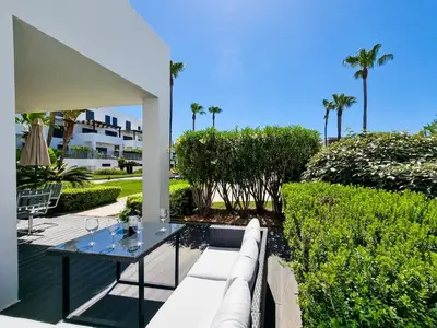 a patio with a white couch and a table at FLH Vilamoura Villa Rosa Golf Apartment with Pool in Vilamoura