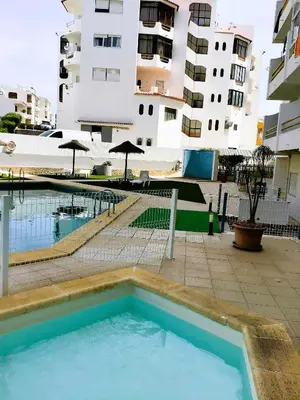 a swimming pool in front of a building at 1 Bedroom Apartment Chaves, Praceta Vitorino Nemesio, Albufeira in Albufeira