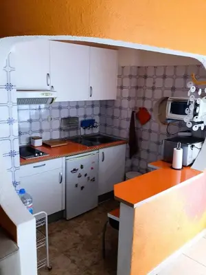 a small kitchen with white cabinets and a counter at 1 Bedroom Apartment Chaves, Praceta Vitorino Nemesio, Albufeira in Albufeira