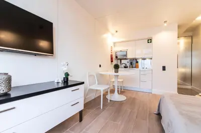 a bedroom with a bed and a kitchen with a table at BmyGuest - Oura Beach Studio I in Albufeira