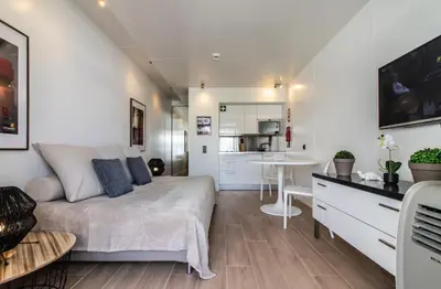 a bedroom with a large bed and a kitchen at BmyGuest - Oura Beach Studio I in Albufeira