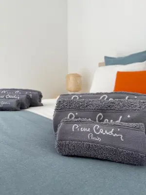 a bedroom with a bed with two black blankets at Vitamin Sea Vilamoura in Quarteira