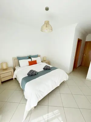 a white bedroom with a large bed in a room at Vitamin Sea Vilamoura in Quarteira
