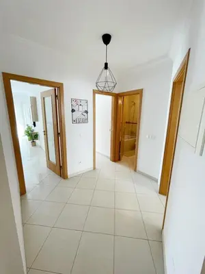 a hallway with two doors and a tile floor at Vitamin Sea Vilamoura in Quarteira