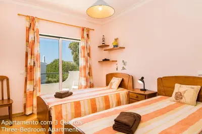 two beds in a room with a window at Akisol Albufeira Sunny in Roja- Pé