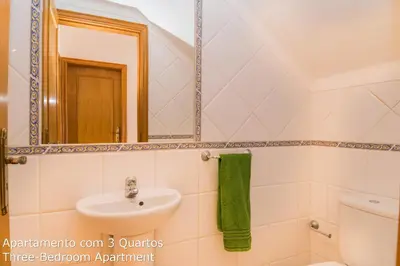 a bathroom with a sink and a toilet and a mirror at Akisol Albufeira Sunny in Roja- Pé