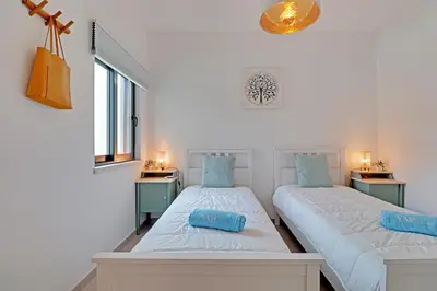 two beds in a room with two night stands at Andiamo Apartment in Vilamoura