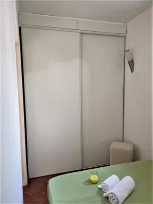 a room with two sliding doors with towels on a table at Casinha nas Açoteias in Olhos de Água