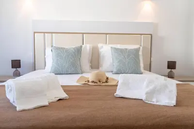 a bed with two towels and a hat on it at Beach Loft in Quarteira