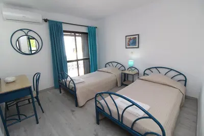 a room with three beds and a table and a table sidx sidx sidx at Apartamento T2 Praia de São Rafael Hibiscus 41A - Albufeira, Algarve in Albufeira