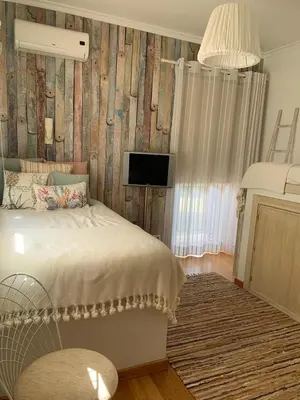 a bedroom with a bed and a tv on a wall at Casa de Férias com piscina - Condominio Vilamouraténis in Vilamoura