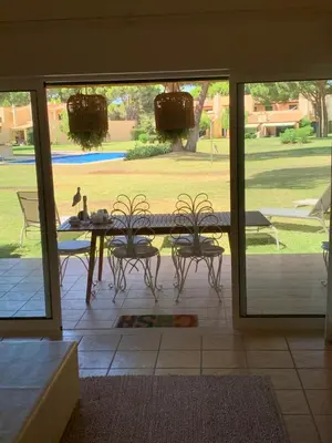 a patio with a table and chairs and a view of a yard at Casa de Férias com piscina - Condominio Vilamouraténis in Vilamoura