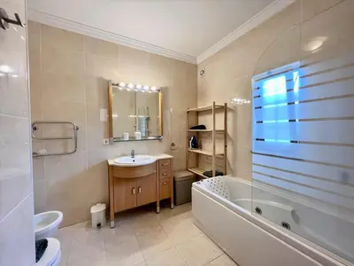 a bathroom with a tub and a sink and a bath tub at Albufeira Terrace With Pool by Homing in Albufeira