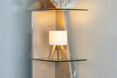 a glass table with a lamp next to a television at Marina Views in Quarteira