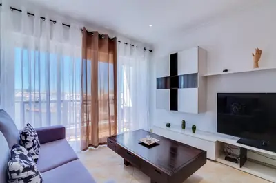 a living room with a couch and a tv at AL - Quarteira Old Town in Quarteira