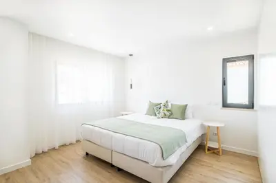 a white bedroom with a bed and a window at Atlantis Luxury Villa by Atlantic Places in Albufeira