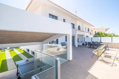 a balcony of a house with a glass patio at Atlantis Luxury Villa by Atlantic Places in Albufeira