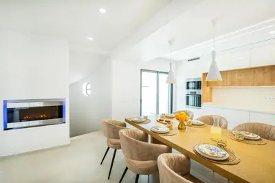 a kitchen and dining room with a long wooden table and chairs at Atlantis Luxury Villa by Atlantic Places in Albufeira