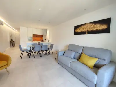 a living room with a blue couch and a kitchen at Sonho Azul in Albufeira