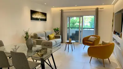 a living room with a couch and a table and chairs at Sonho Azul in Albufeira